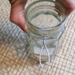 Placing the loop on one side, wrap the wire tightly around the mouth of the jar.