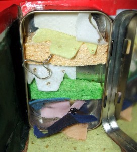 This Altoids tin closet features sponge shelves, and hangers made with packaging wire.